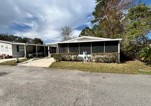 Single-story house with screened porch and driveway.